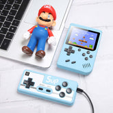 Retro Mini Handheld Game Console next to a toy figure and a game controller on a desk.