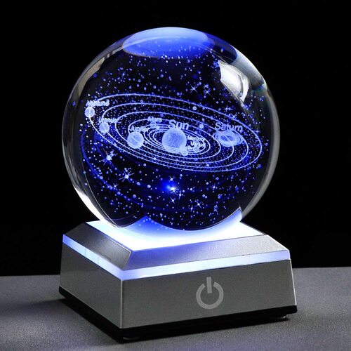 3D Crystal Galaxy Ball illuminated, displaying a mini-universe with stars and planets on a desk.