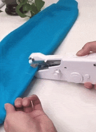 Handheld Sewing Machine fixing a blue fabric quickly and easily on a table.