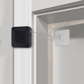 Automatic Door Closer installed, showing inductive mechanism for no-drill setup in door frame, ideal for pet-proof home security.