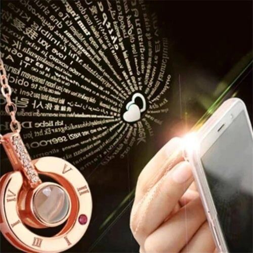 Close-up of 100 Languages I Love You Necklace projecting words with a smartphone light