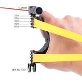 Hand holding a Laser Guided Slingshot with yellow bands, featuring a laser sight and distance markers from 10m to 50m for precision aiming.