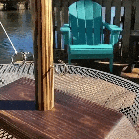 Ring Toss Hook Game on a table near a lake with a turquoise chair in the background.