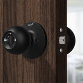Keyless Smart Knob with App Control installed on a wooden door, showcasing its sleek black design and functionalities.